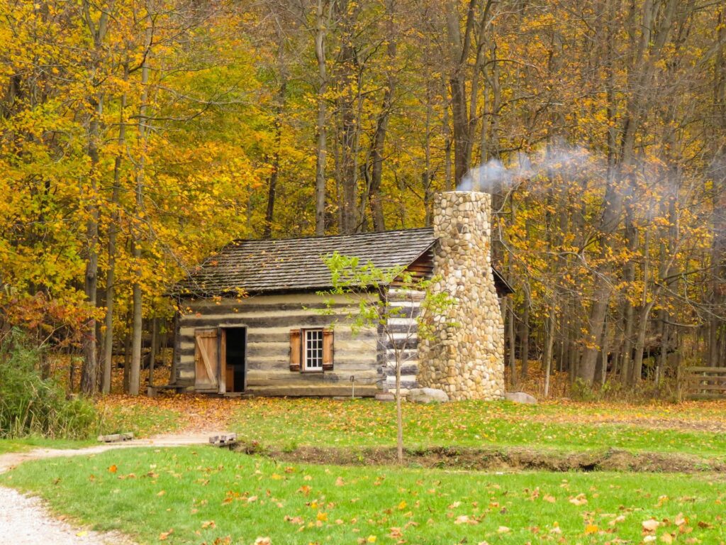Haus aus Holz und Stein mit rauchendem Schornstein