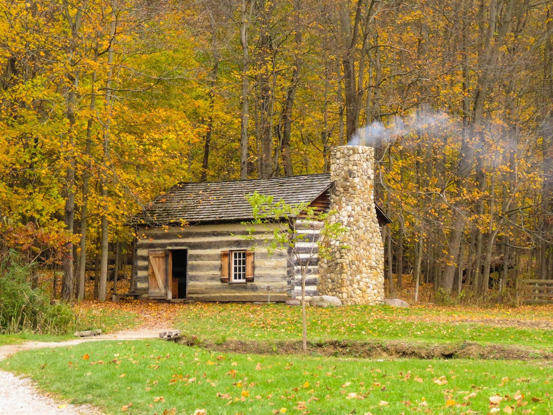 Haus aus Holz und Stein mit rauchendem Schornstein